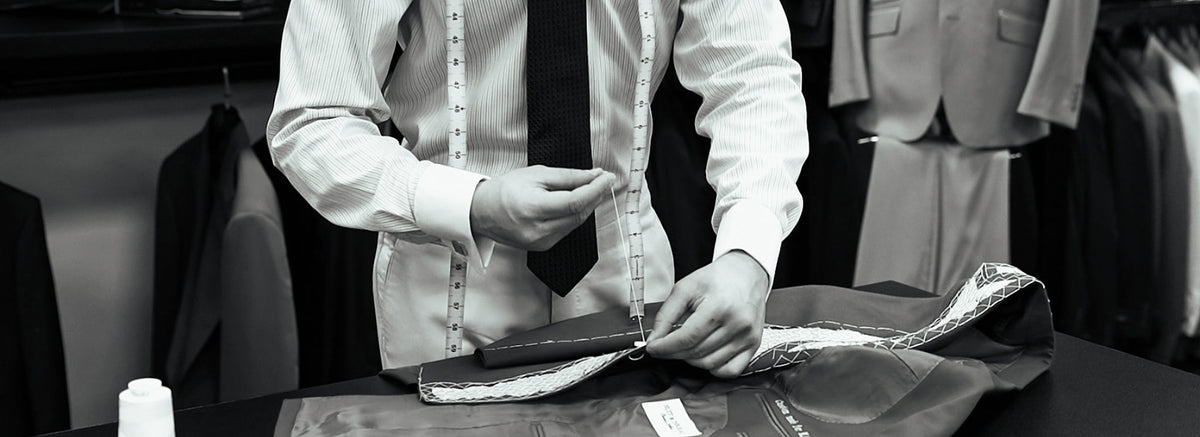 Man adjusting a suit jacket in a tailor shop